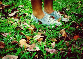 Low section of woman standing on grass