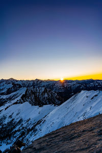 Scenic view of snowcapped mountains against clear sky during winter