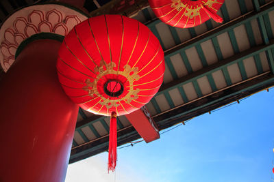 Low angle view of illuminated lanterns hanging against sky