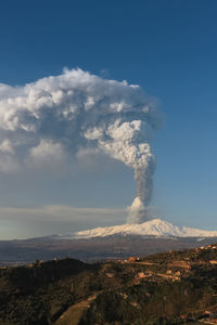 Smoke emitting from volcanic mountain against sky