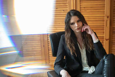 Young woman sitting on chair at home