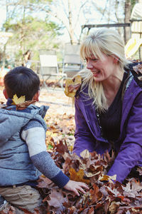 Girl and woman with autumn leaves outdoors