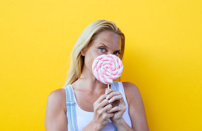 Portrait of woman holding marshmallow candy