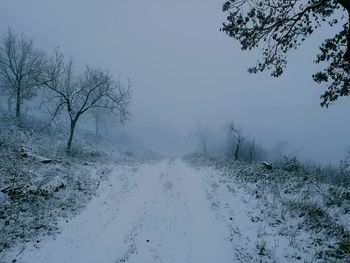 Scenic view of snow covered land against sky