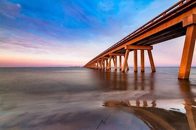 Pier on sea at sunset