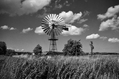 Traditional windmill on field against sky