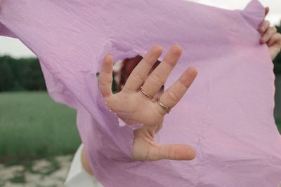 Close-up of woman hand by pink flowering plant