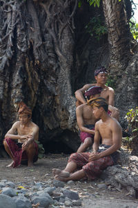 Portrait of traditional people sitting on rock