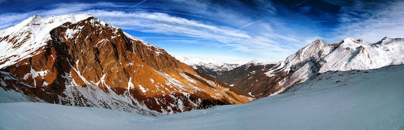 Scenic view of snowcapped mountains against blue sky