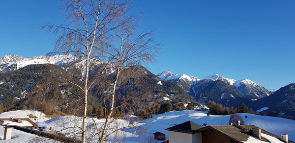 Scenic view of snowcapped mountains against clear blue sky