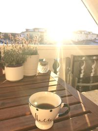 Coffee cup on table against sky