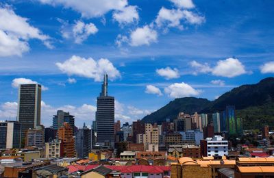 Buildings in city against cloudy sky