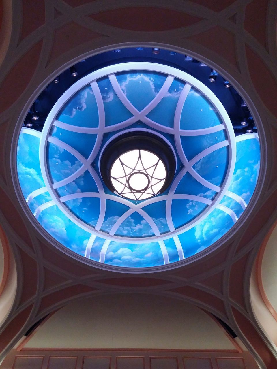 low angle view, architecture, built structure, indoors, window, ceiling, circle, pattern, glass - material, design, architectural feature, dome, arch, directly below, geometric shape, building exterior, ornate, skylight, no people, church