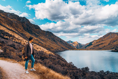 Man standing by lake against sky