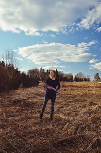 Woman standing on field against sky