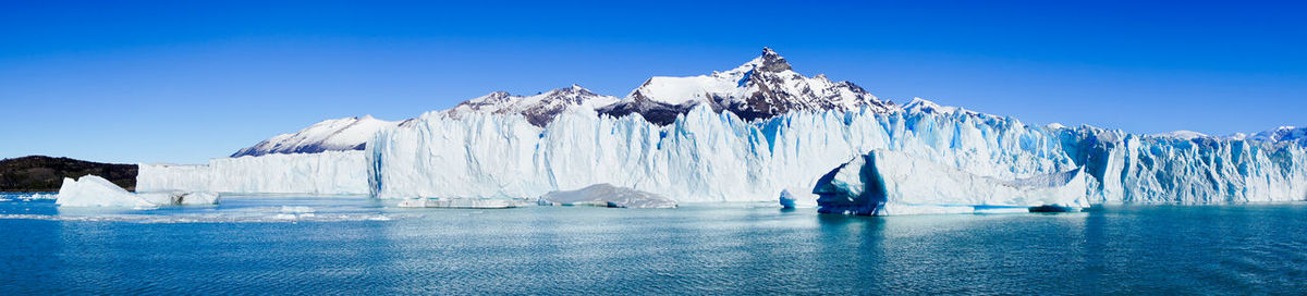 Panoramic view of frozen sea against clear blue sky