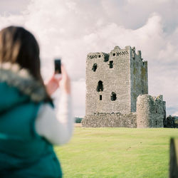 Reflection of man photographing on mobile phone