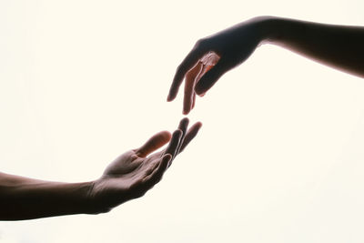 Close-up of hand holding paper over white background