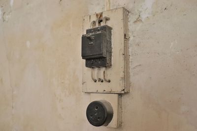 Close-up of old telephone booth on wall