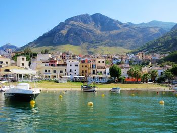 Scenic view of town by mountains against sky