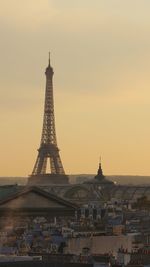 Tower in city against sky during sunset