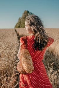 Woman standing on field against sky