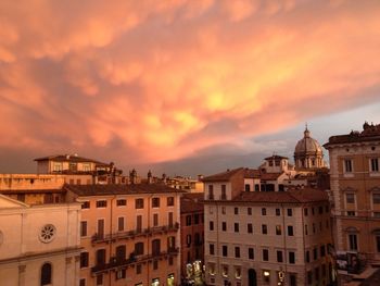 Buildings against cloudy sky at sunset