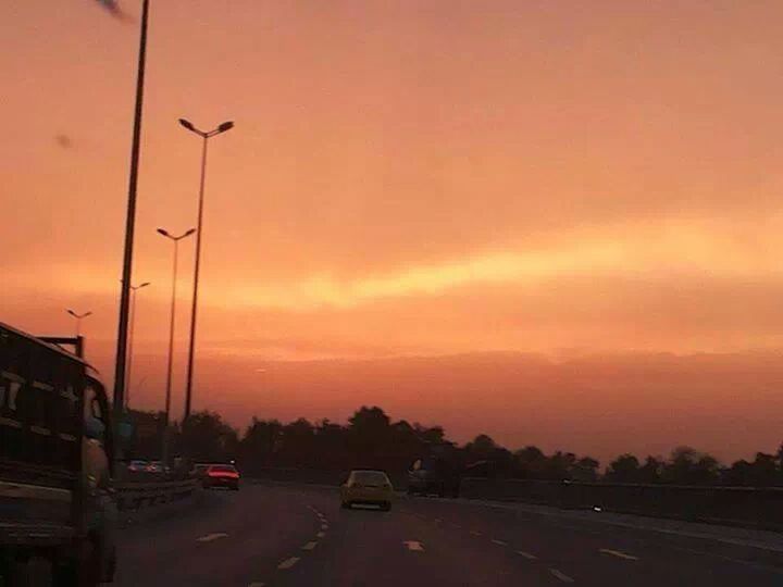 transportation, car, sunset, land vehicle, mode of transport, road, orange color, sky, street, on the move, street light, traffic, road marking, cloud - sky, the way forward, travel, silhouette, outdoors, city, tree