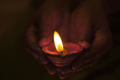 Close-up of lit candle in the dark