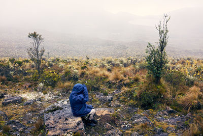 Rear view of man walking on mountain against sky