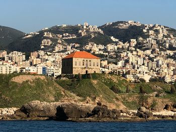 Townscape by sea against clear sky