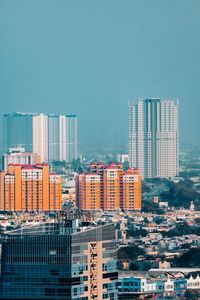 Buildings in city against clear sky