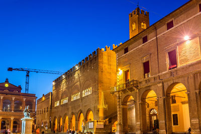 Low angle view of illuminated buildings against sky at dusk