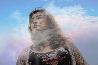 Portrait of young man looking away against sky