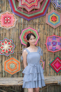 Portrait of young woman standing against wall