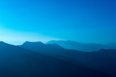 Scenic view of mountains against clear blue sky