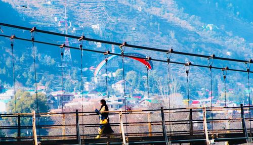 Man walking on bridge in city