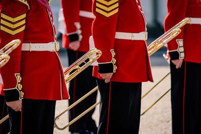 Midsection of men holding musical instruments