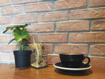 Coffee and potted plant against wall