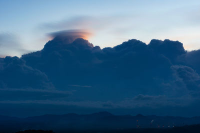 Low angle view of silhouette mountains against dramatic sky