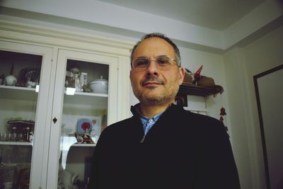 Portrait of mature man standing at home