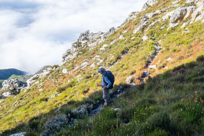 Hikers with backpack standing on a slope looking at mountain and cloud view 