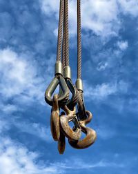 Low angle view of chain against sky