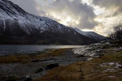 Scenic view of lake by mountains against sky