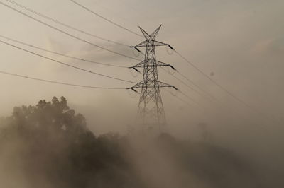 Low angle view of electricity pylon against sky