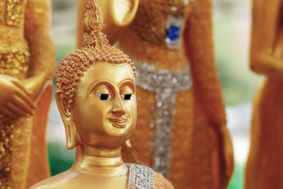 Close-up of buddha statue against tree