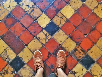 Low section of man standing on tiled floor