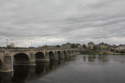 Arch bridge over river against sky