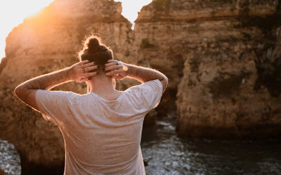 Rear view of woman standing on rock