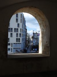 Buildings against sky seen through window